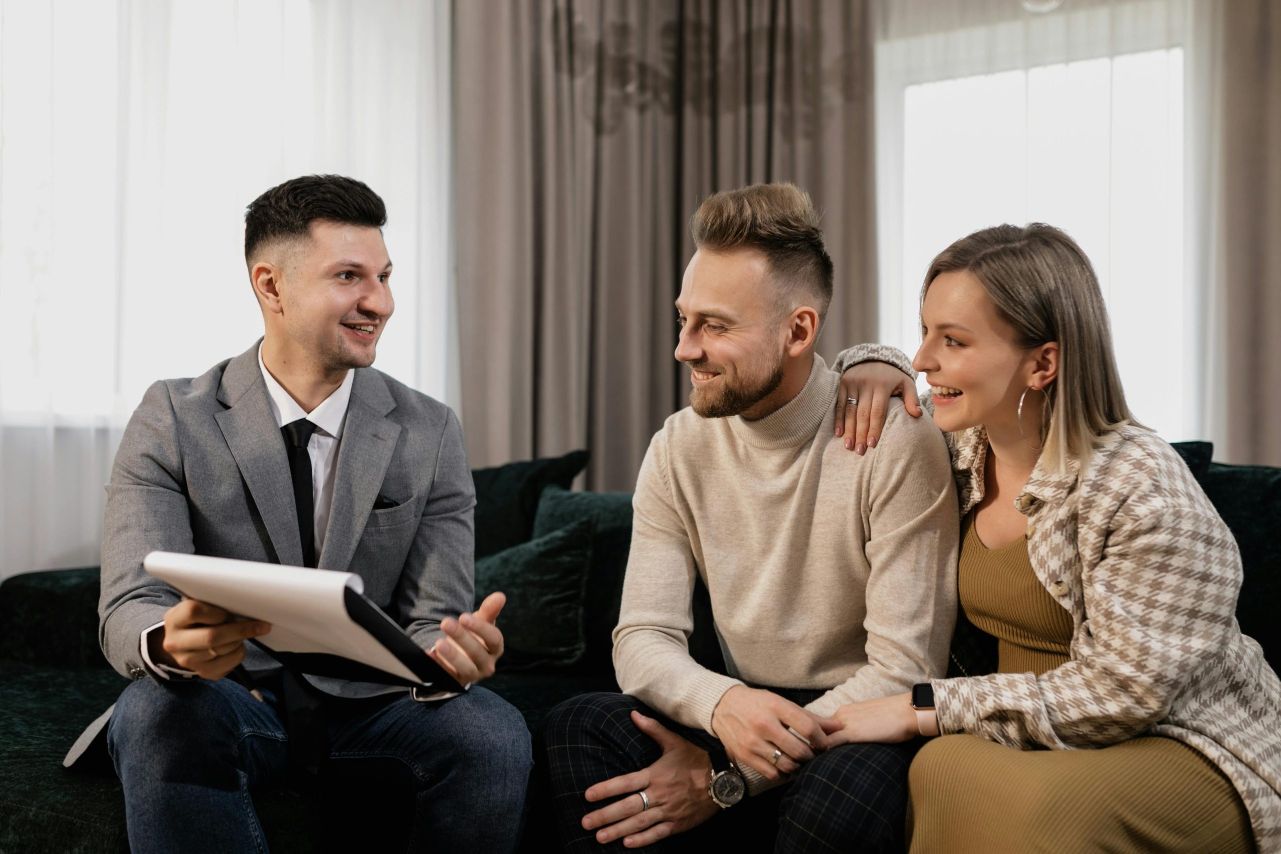 couple and realtor discussing while seated on a couch