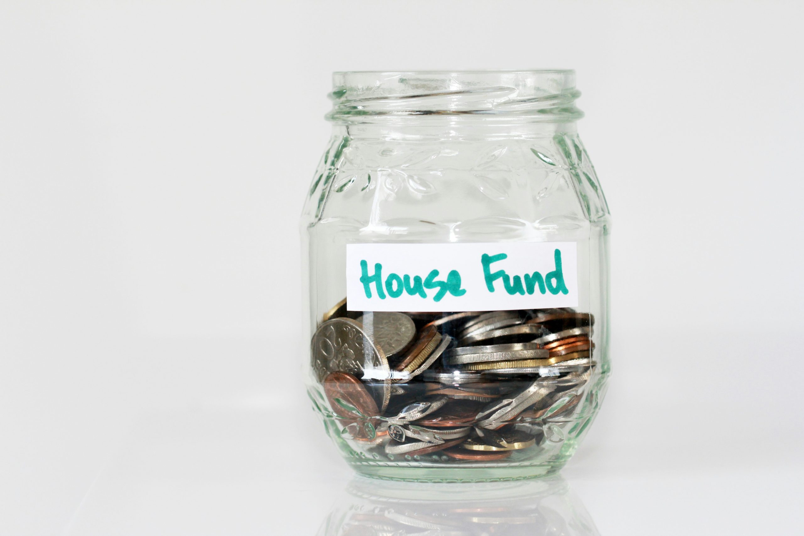 coin-filled jar labeled 'house fund'