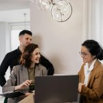 homeowners-to-be sitting at a desk, negotiating house price with seller